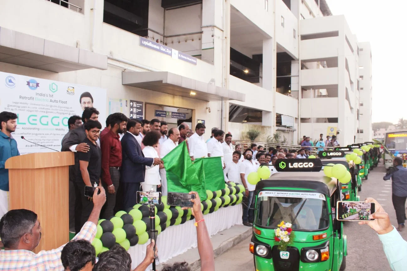 Officials flagging off a balloon-decorated Leggo auto in front of a crowd